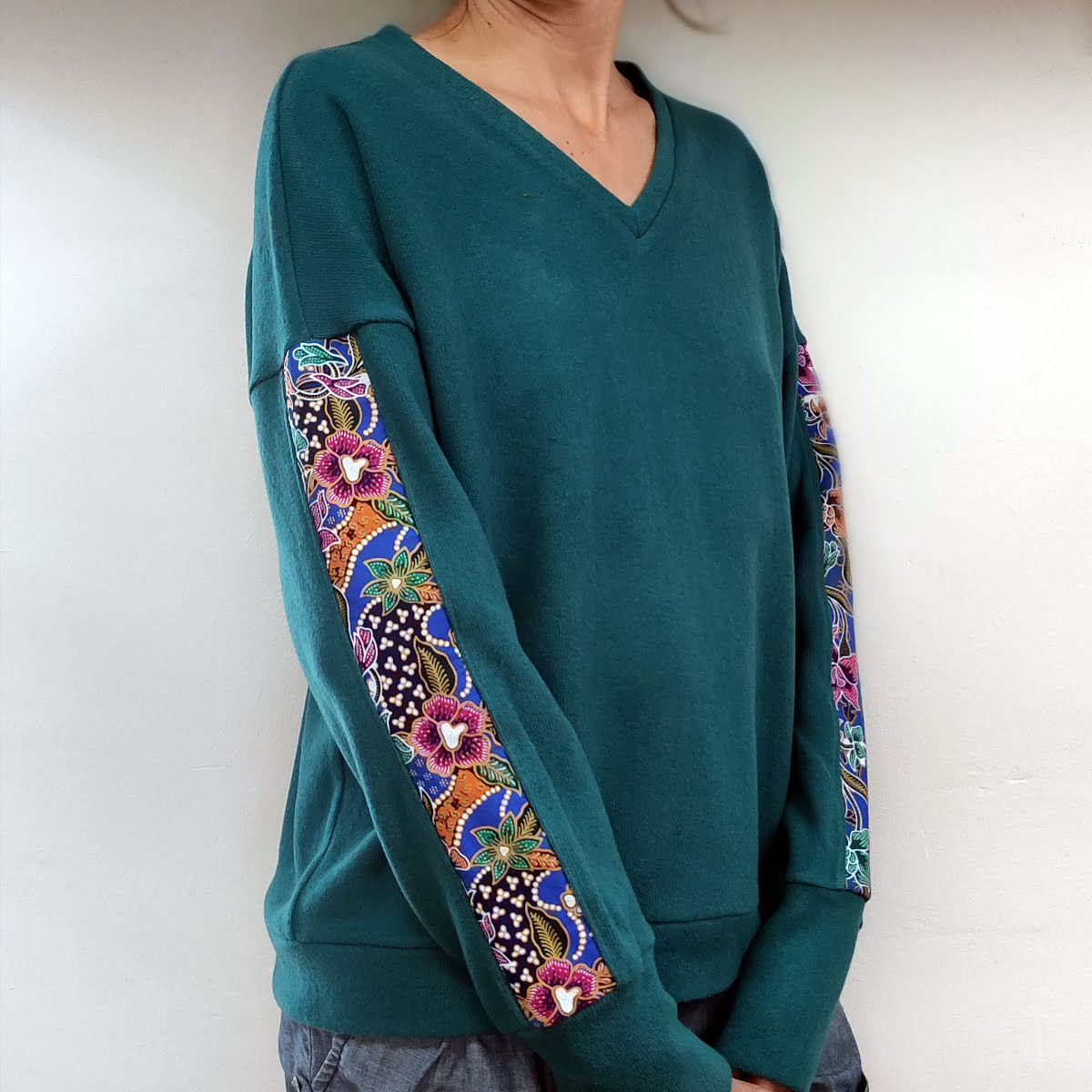 pull col V fait main artisanalement à albertville, en maille coton italienne, chuad et doux, de couleur turquoise, manche motifs batik indonésien