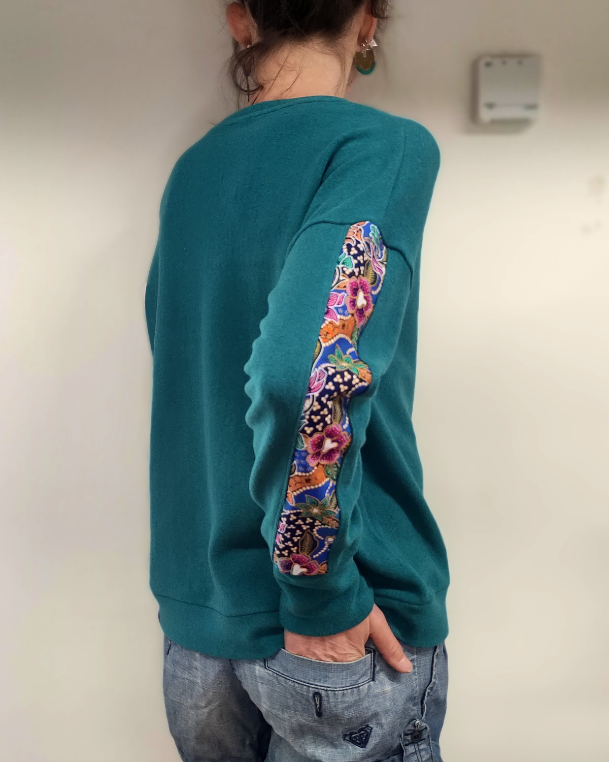 pull col V fait main artisanalement à albertville, en maille coton italienne, chuad et doux, de couleur turquoise, manche motifs batik indonésien