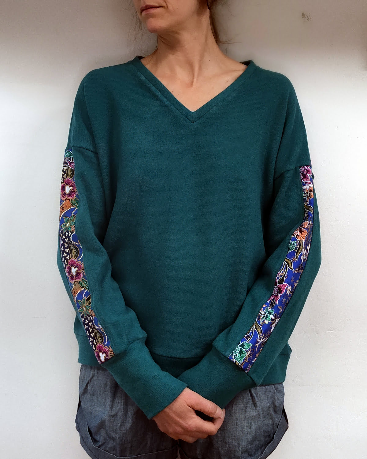 pull col V fait main artisanalement à albertville, en maille coton italienne, chuad et doux, de couleur turquoise, manche motifs batik indonésien